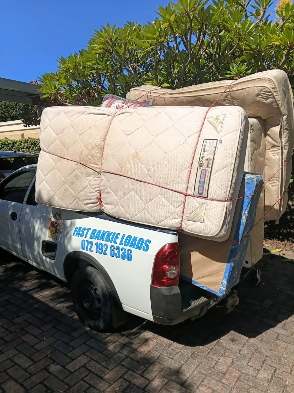 Stack of mattresses strapped down in bakkie bed